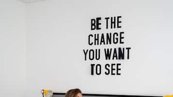 A person sitting on a bed in a room with a motivational quote on the wall.