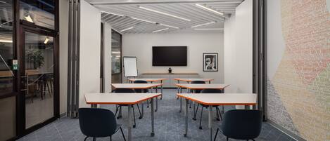A modern conference room with a whiteboard, a large screen, and a patterned wall.