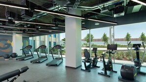 Ein Fitnessstudio mit Laufbändern, Crosstrainern und Kurzhanteln.