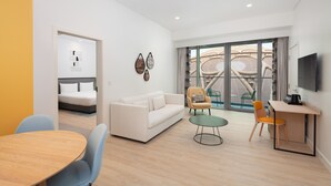 Een moderne woonkamer met een bank, stoelen, een eettafel en een televisie.