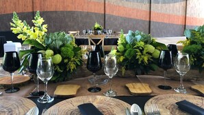 A dining table set with wine glasses, cutlery, and decorative foliage. - BV Hotel Atlixco (Atlixco)