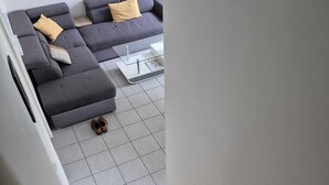 A staircase leading to a living area with a grey sofa set and a white coffee table. - Hortillonne (AMIENS)