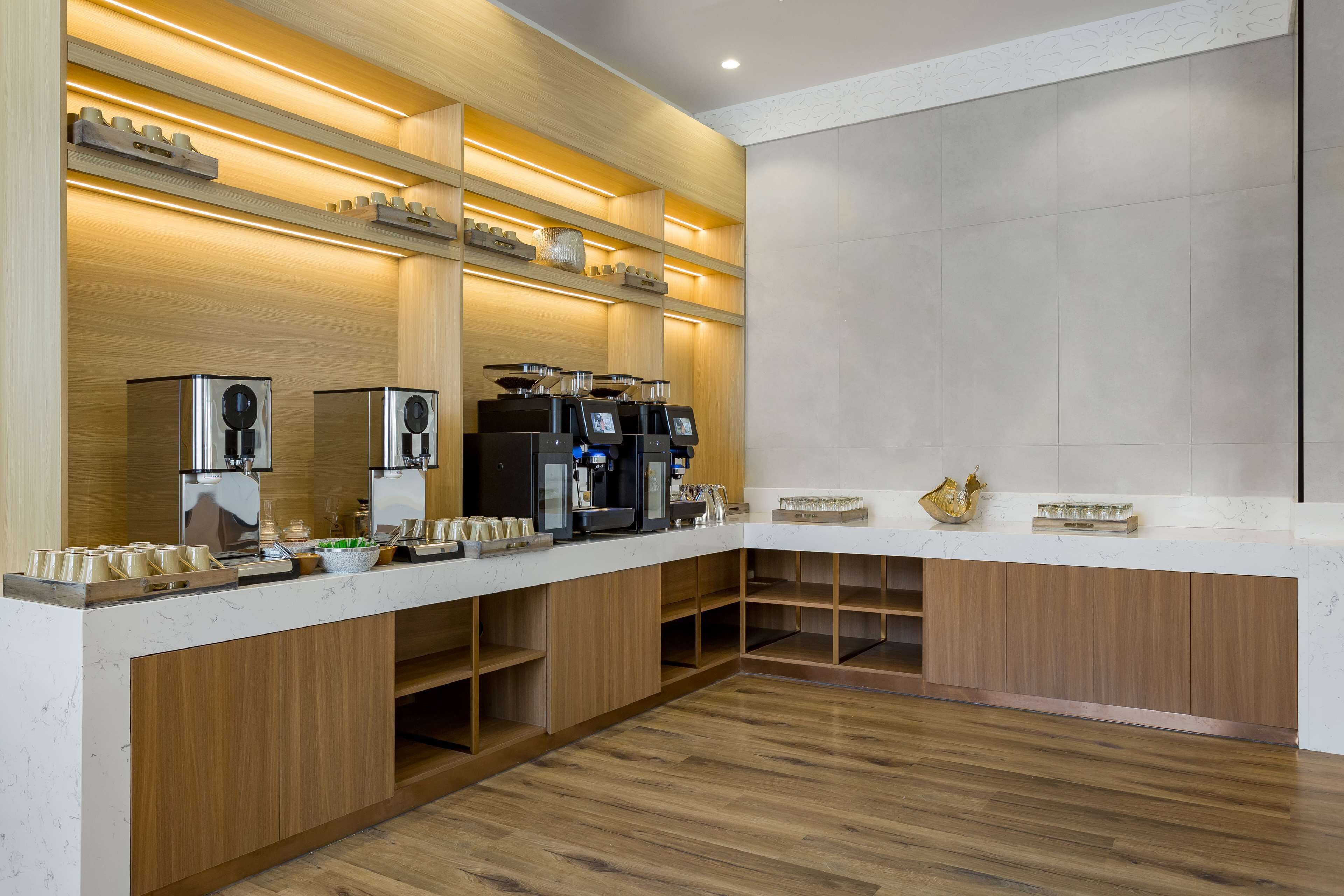 A modern kitchen with built-in appliances, wooden cabinets, and a marble countertop.