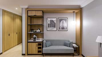 A modern room with a grey sofa, wooden shelving unit, and two framed pictures on the wall.