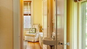 A hallway with a wooden floor leading to a bedroom with a bed, a chair, and a window. - Orchard & Mountain Views, 5Mi Wintergreen, Gourmet Kitchen (Massies Mill)