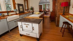 A kitchen with wooden cabinets, a stove, and a dining area with a table and chairs. - Orchard & Mountain Views, 5Mi Wintergreen, Gourmet Kitchen (Massies Mill)