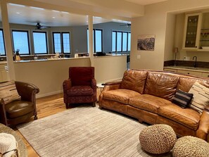 A living room with a leather sofa, a red armchair, and a coffee table.