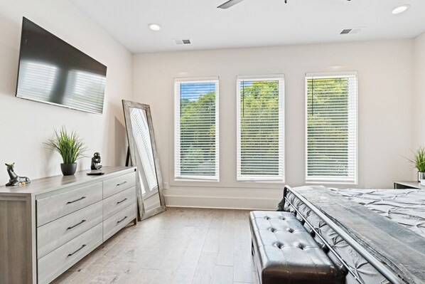 A bedroom with a bed, a dresser, and a TV on the wall. - *SLEEPS 12* Keep the Secret *EAST NASH1* 4BR* 4BA* (Nashville)