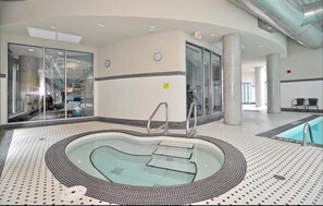 Relax by the oval-shaped pool surrounded by a patterned tile floor and supported by pillars.