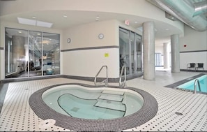 Relax by the oval-shaped pool surrounded by a patterned tile floor and supported by pillars.
