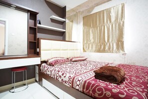 Une chambre à coucher avec un lit, un miroir, une fenêtre avec des rideaux et un tabouret.