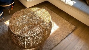 A modern living room with a beige sectional sofa, a round woven ottoman, and a decorative chandelier. - Departamento Villa Neek (San Cristóbal de las Casas)
