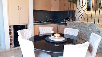 Departamento Deluxe | Cocina privada | Cafetera y tetera, toallas de papel y comedor