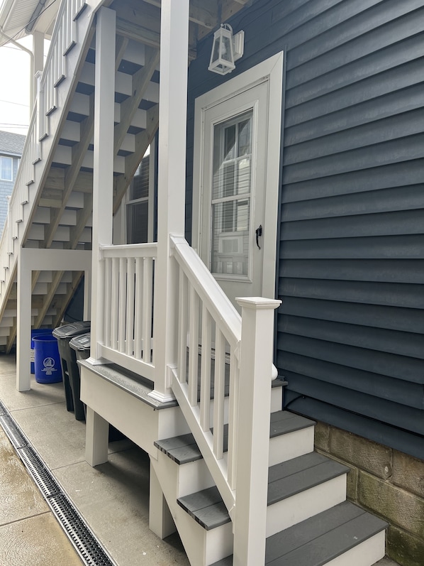 A residential house with a front porch, a staircase, and a door with a window.
