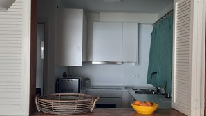 A compact kitchen with white cabinets, a toaster, a stove, and a yellow bowl on the counter. - Apartment in front of the beach and with free parking in the same building. (Altea)