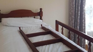 A bed with a wooden frame, a white mattress, and a headboard.
