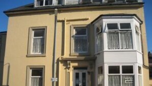 A multi-story building with a bay window on the second floor.