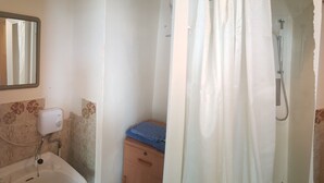 A bathroom with a shower, toilet, and sink.