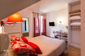 A bedroom with a bed, a bedside lamp, a TV, a desk with a chair, and a wardrobe. - Logis Hôtel Etchemaïté (Doué-en-Anjou)