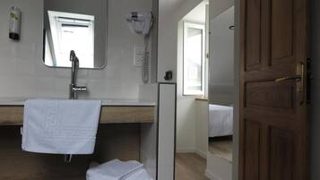 A bathroom with a mirror, towel rack, and a hairdryer.