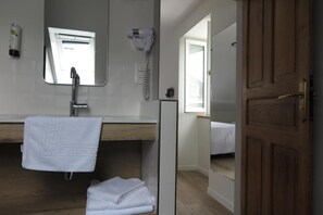 A bathroom with a mirror, towel rack, and a hairdryer. - Logis Hôtel Etchemaïté (Doué-en-Anjou)
