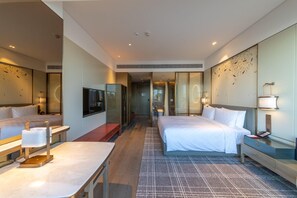 Una habitación de hotel con dos camas, un escritorio, un televisor y un baño.