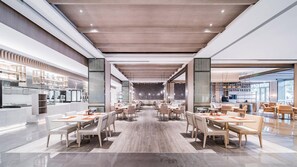 Un vaste espace dédié à la salle à manger, doté de hauts plafonds, d’un éclairage moderne et d’un aménagement centralisé des sièges.