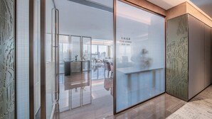 A modern lounge area with a glass partition, a seating area with chairs and tables, and a city view. - Hualuxe Xi'an Chanba (Xi'an)