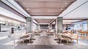 A spacious dining area with high ceilings, modern lighting, and a central seating arrangement.
