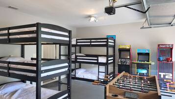 Relax in a dormitory-style room with three comfortable beds, a foosball table, and a projector for entertainment.