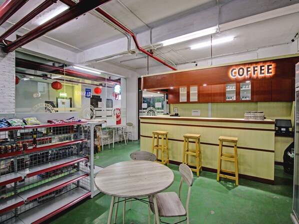 Ein Café-Interieur mit einer Theke, Hockstühlen und einer Auswahl an Kaffeeprodukten.