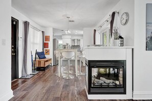 A modern kitchen with white cabinets, a built-in oven, and a dining area with a white table and chairs. - Waterfront 2BR Home Heated Pool BBQ Parking! (Fort Lauderdale)
