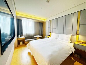 A hotel room with a large bed, a bedside table, a round table, and a window with curtains. - Ji Hotel (Shanghai)