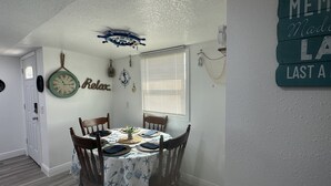 A dining area with a table set for four, nautical-themed wall decorations, and a sign reading "MEM MADE LAST A". - Buckhead ridge fishing headquarters (Okeechobee)