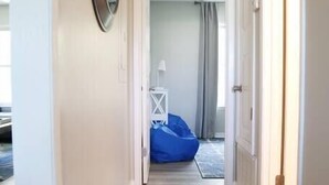 Ein Flur mit Holzboden, einem Spiegel links und einem blauen Sitzsack im Hintergrund.