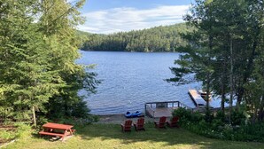 Une terrasse au bord du lac, avec des sièges extérieurs et une jetée qui s’avance dans l’eau.