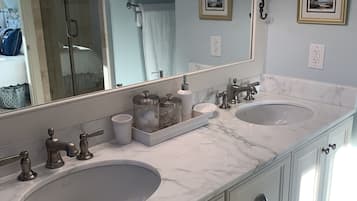 A bathroom with two sinks, a large mirror, and a vanity with drawers.