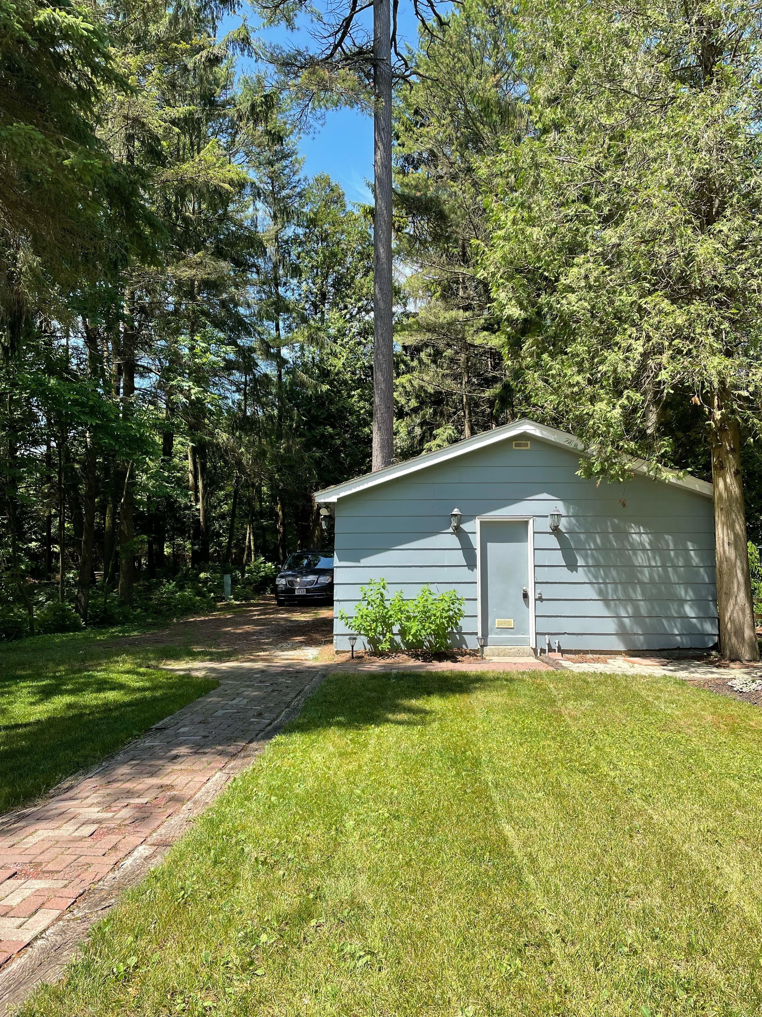 A small, single-story building with a flat roof, a front door, and a small porch area.