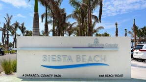 A sign for Siesta Beach, a Sarasota County park, located at 948 Beach Road. - Condo# 415 2 Bed/1 bath Condo Steps to Siesta Key Beach! (Sarasota)