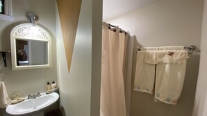 A bathroom with a sink, mirror, and towel rack. - Hilda’s Garage Bandera, TX (Bandera)