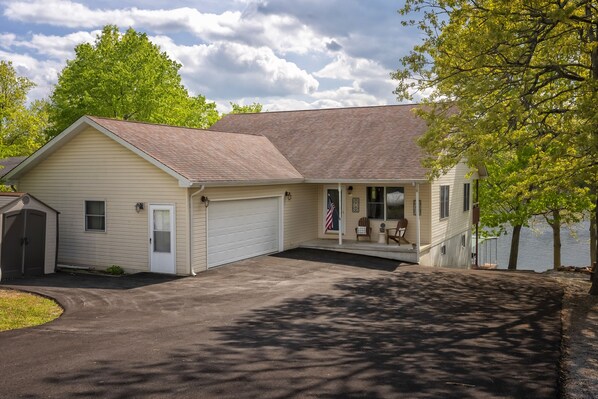 A single-story house with a garage, a covered porch, and a small deck.