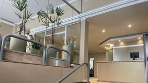 A modern hotel lobby with a marble staircase, potted plants, and a reception desk. - Bravo City Hotel São Jose do Rio Preto (São José do Rio Preto)