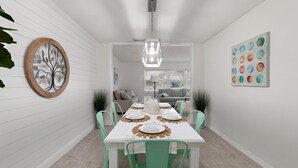 A dining area with a white table set for six, surrounded by mint green chairs. A wooden tree wall art piece is on the left, and a colorful abstract painting is on the right. - PROMO 5% WEEKLY AND 10% MONTHLY DISCOUNT
Private Beach Back Yard ! 5 BR 2 Bath  (Bradenton)