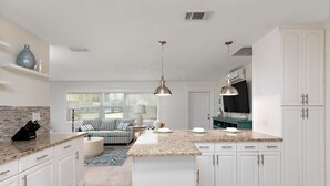A modern kitchen with white cabinetry, granite countertops, and pendant lighting. - PROMO 5% WEEKLY AND 10% MONTHLY DISCOUNT
Private Beach Back Yard ! 5 BR 2 Bath  (Bradenton)