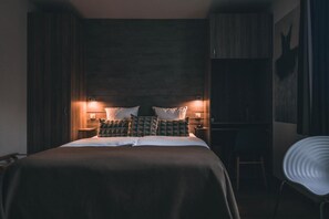 A bedroom with a large bed, two bedside tables with lamps, a chair, and a wardrobe. - Logis Hôtel Frankenbourg (Rocamadour)