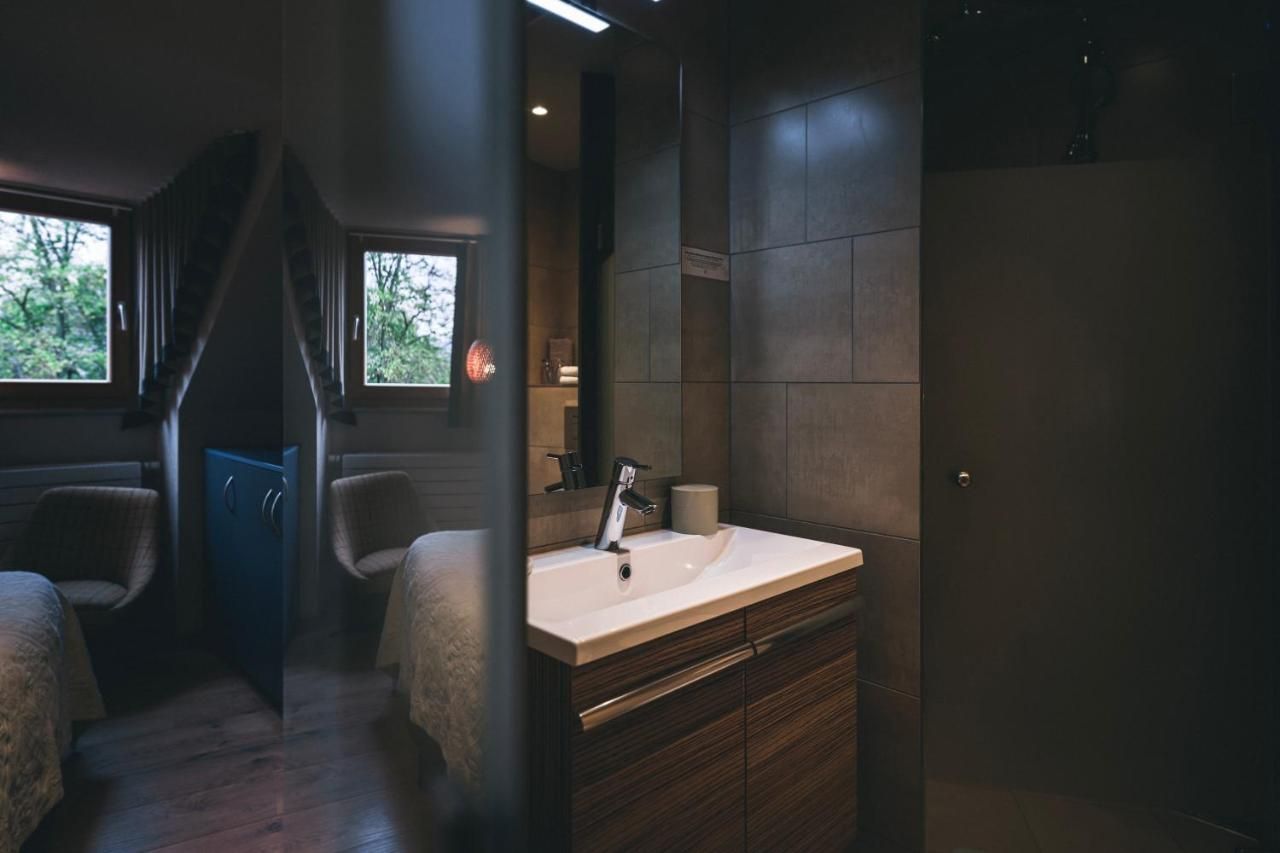 Un baño moderno con un lavamanos grande, muebles de madera oscura y vistas al exterior a través de una ventana.