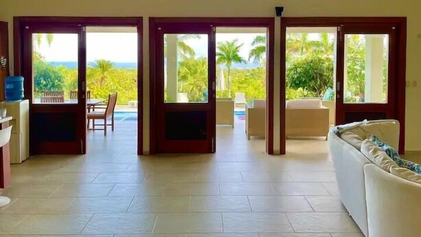 A spacious room with a large sliding glass door leading to an outdoor area with a pool and patio furniture.