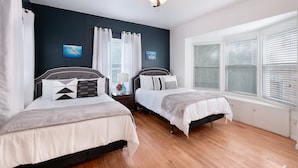 A bedroom with two beds, a ceiling fan, and a large window with blinds. - F1 •  30% OFF • Updated, Cozy & Clean • Fast WiFi • 2BR/2BA Monthly Rental (San Antonio)