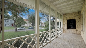 A covered porch with a stone wall and a lattice railing. - F1 •  30% OFF • Updated, Cozy & Clean • Fast WiFi • 2BR/2BA Monthly Rental (San Antonio)