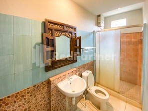 A bathroom with a sink, toilet, and shower. - Istana Griya 2 Hotel (Surakarta)